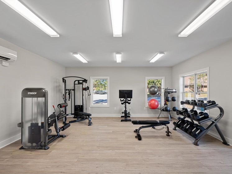 a gym with treadmills and other exercise equipment on a wooden floor